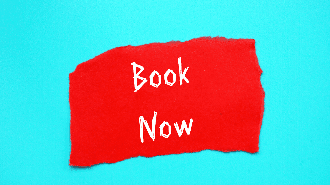 A red torn paper with "Book Now" written in white, placed on a bright blue background, representing the importance of easy online booking for salon websites.